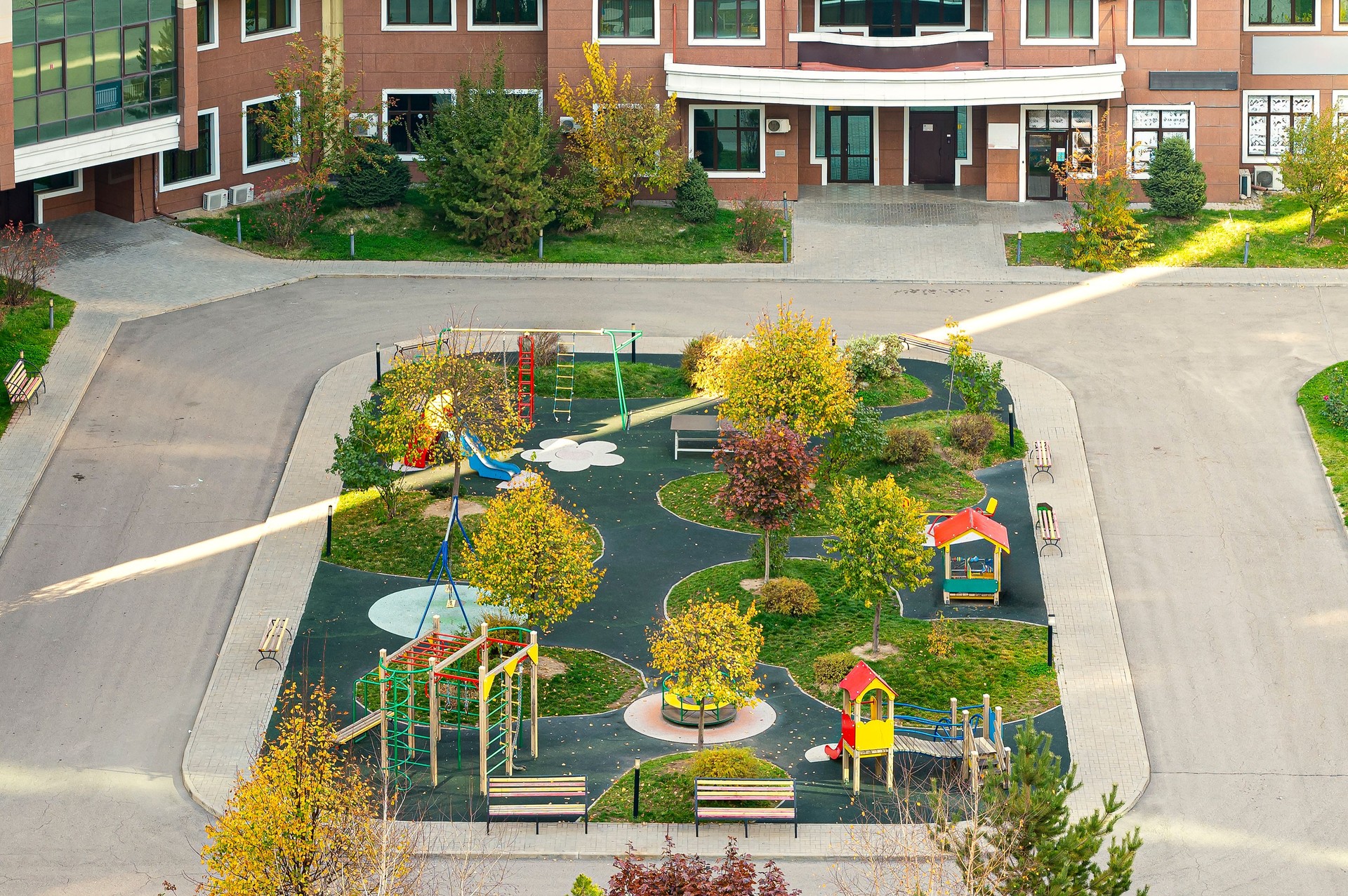 Modern residential courtyard. Real estate low-rise construction building exterior and playground for children in new residential area for sale.. Image of the urban development concept.