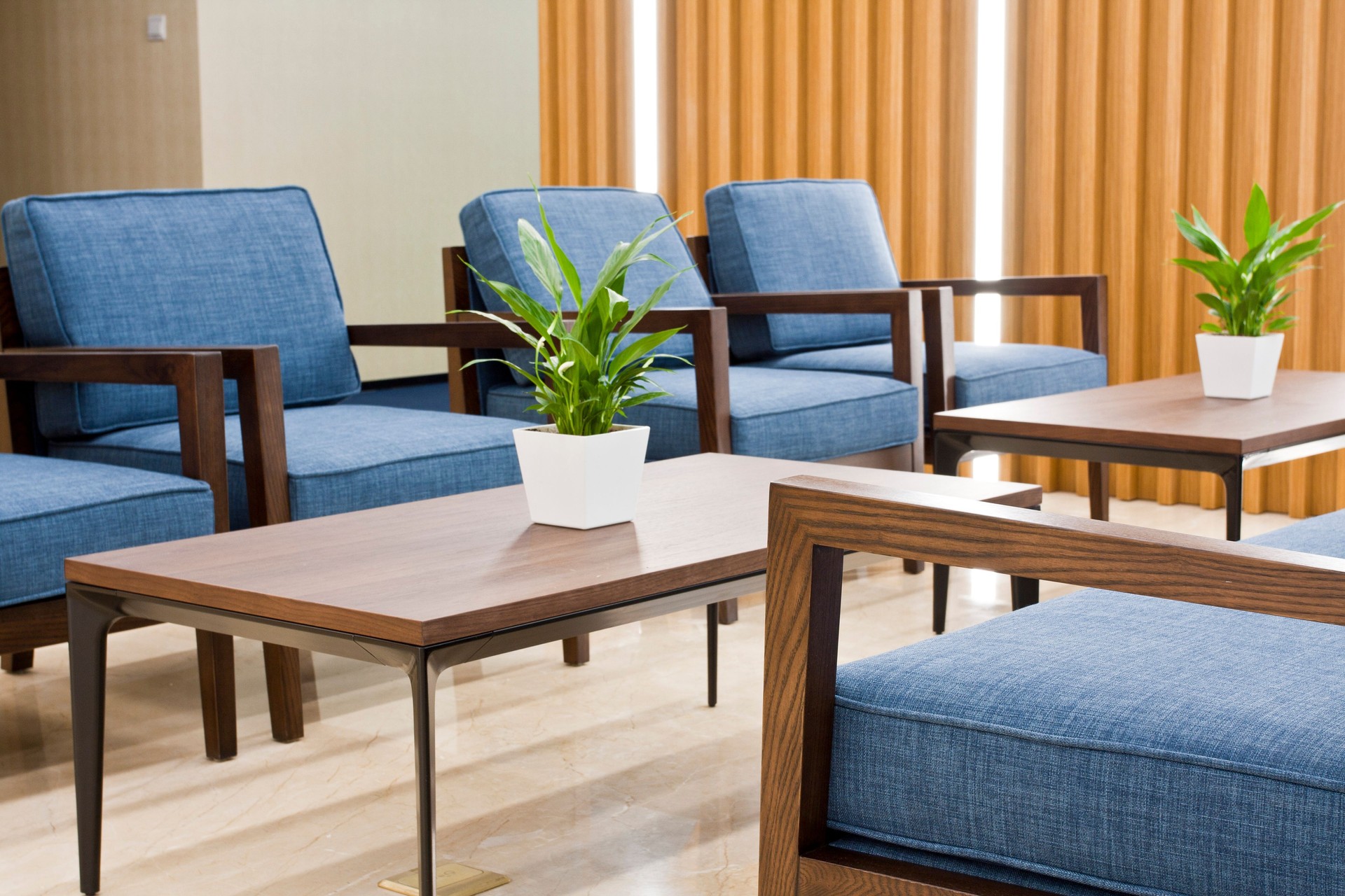 Office waiting area with sofa, armchairs, large wooden table